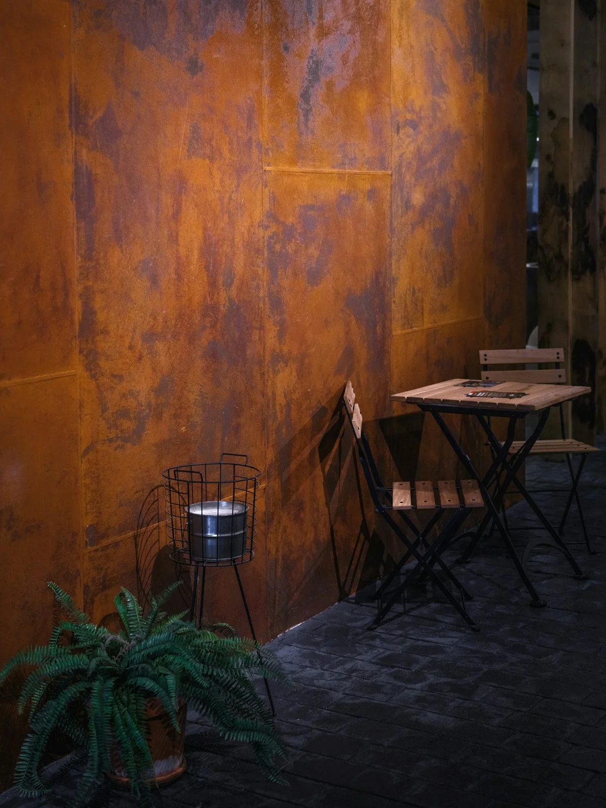 Perete Corten într-un spațiu HoReCa — fațadă metalică oxidată cu efect industrial, finisaj natural